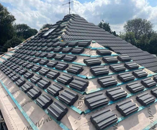 This is a photo of a new hip roof being installed. New felt, battens, and grey tiles have been installed, also a new velux window. Works carried out by LKN Roofing Shortstown